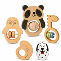 A set of wooden baby rattle toys with animal faces, including a panda, bird, giraffe, duck, and dalmatian, arranged on a clean white background.